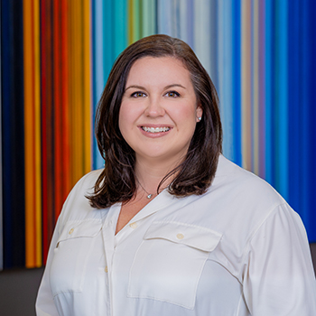 Professional woman smiling, colorful striped background.