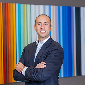 Professional in suit with colorful striped background.